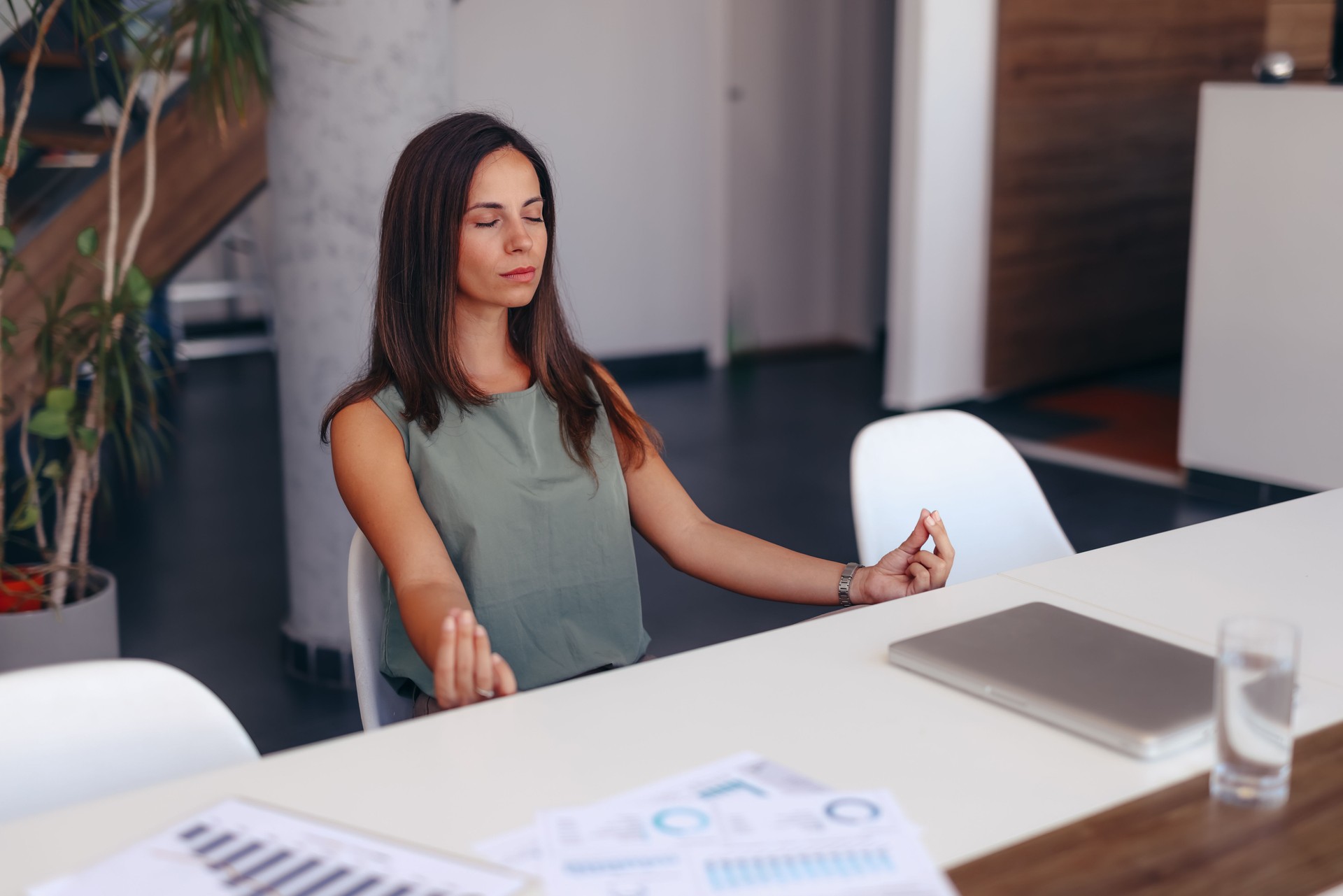 Businesswoman Practicing Meditation at Office Desk for Stress Relief