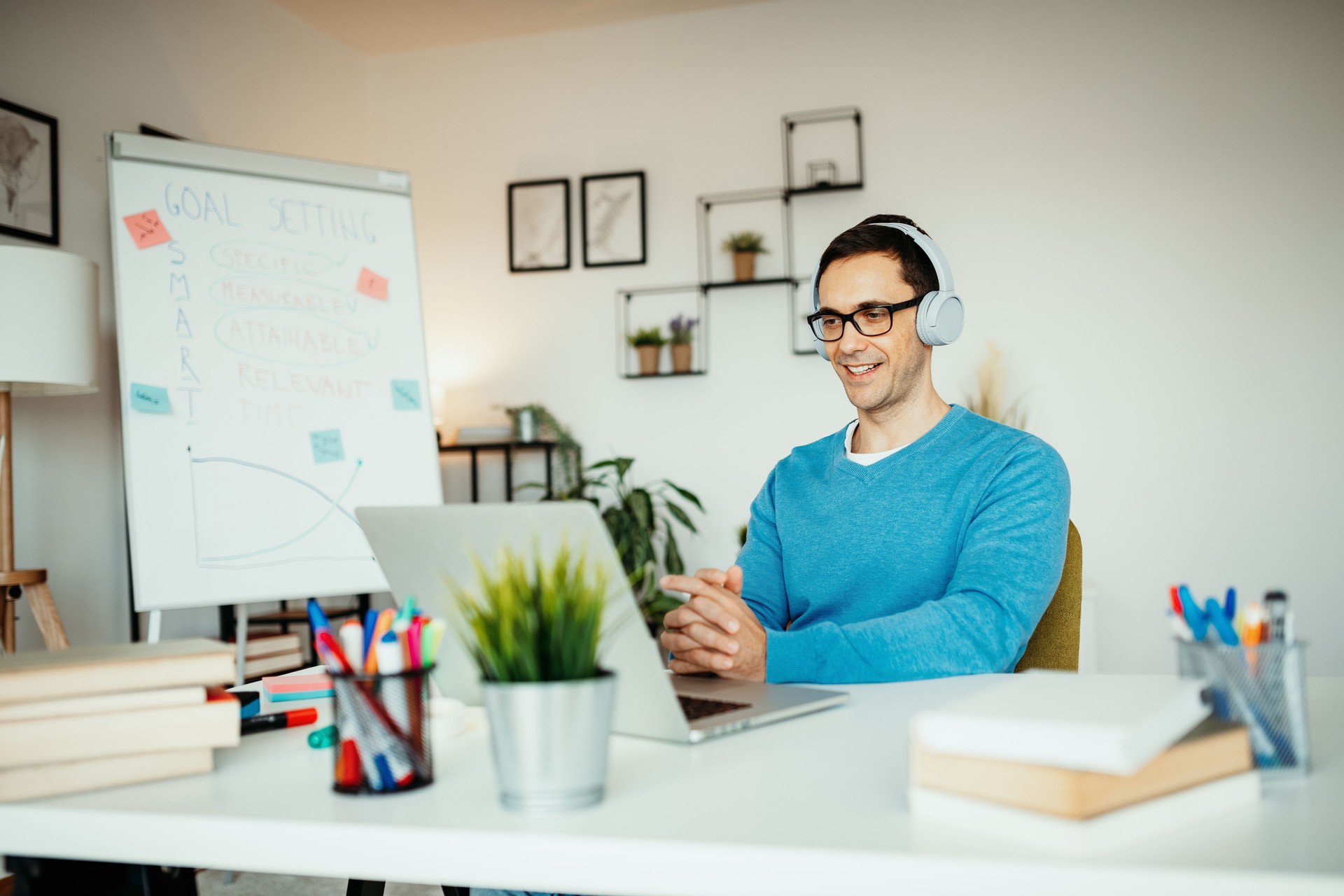 Mature life coach having online lectures, using laptop and whiteboard for students